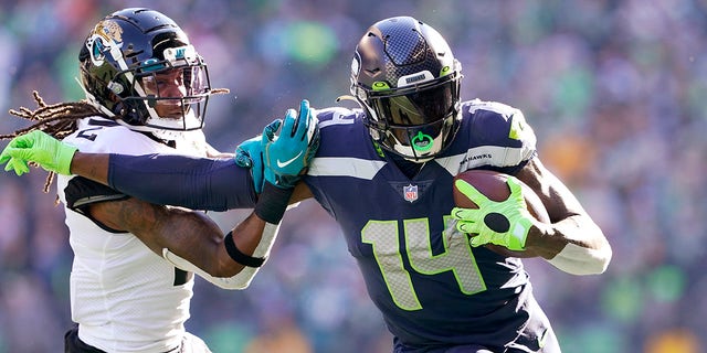 Seattle Seahawks' DK Metcalf (14) pushes off of Jacksonville Jaguars' Rayshawn Jenkins as he runs with the ball during the first half of an NFL football game, Sunday, Oct. 31, 2021, in Seattle.
