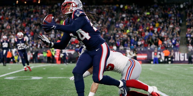 oct 10, 2019; Foxborough, MAMÁ, Estados Unidos; New England Patriots cornerback Stephon Gilmore (24) makes a catch in front of New York Giants tight end Garrett Dickerson (89) during the second half at Gillette Stadium. Mandatory Credit: Paul Rutherford-USA TODAY Sports