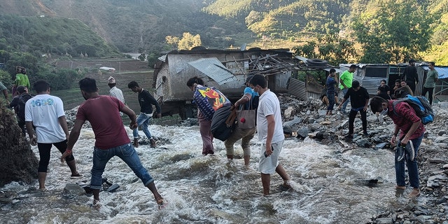 On Thursday, people passed a flooded area in Dipayal Silgadhi, Nepal.