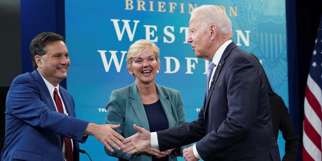 President Biden shakes hands White House Chief of Staff Ron Klain as Energy Secretary Jennifer Granholm looks on as he arrives for a meeting with cabinet officials, governors, and private sector partners to discuss preparedness of Western states to heat, drought and wildfires this season, at the White House in Washington, D.C., June 30, 2021. REUTERS/Kevin Lamarque