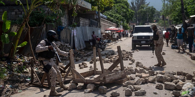 Police remove a roadblock set by protesters in Port-au-Prince, Haiti, on Monday.