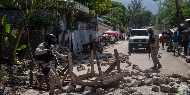 Police remove a roadblock set by protesters in Port-au-Prince, Haiti, on Monday.