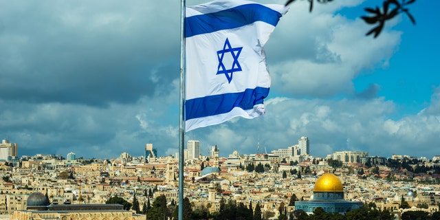 Israeli flag flying over Jerusalem and the Temple Mount