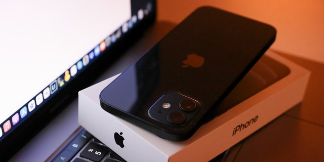 In this photo illustration, Apple's iPhone 12 seen placed on a MacBook Pro. 