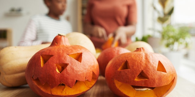 Parents and children who celebrate Halloween usually take part in group activities, like jack-o'-lantern carving.