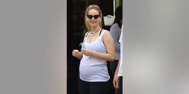 The ‘Hunger Games’ actress's pregnant belly was on full display as she threw her arms around her husband.