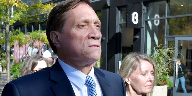 John Wilson, left, and his wife, right, are leaving federal court after being found guilty of participating in a fraudulent admission scheme on Friday, October 8, 2021 in Boston. Wilson and another wealthy parent, Gamal Abdelaziz, were convicted on Friday of buying their children's way into school when athletic recruits in the first case were to go to court in the college admission scandal involving prestigious universities across the country. (AP Photo / Josh Reynolds)