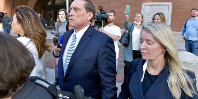 John Wilson, center and his wife, are leaving the right-wing federal court after being found guilty of participating in a fraudulent admission scheme on Friday, October 8, 2021 in Boston. Wilson and another wealthy parent, Gamal Abdelaziz, were convicted on Friday of buying their children's way into school when athletic recruits in the first case were to go to court in the college admission scandal involving prestigious universities across the country. (AP Photo / Josh Reynolds)
