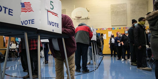 Michigan voters fill out their ballots at a school gymnasium on Nov. 03, 2020, in Lansing.