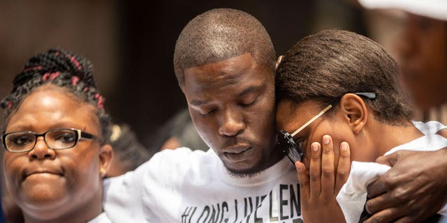 In the July 9, 2021 file photo, from left, Cheryl Frazier, sister of Leneal Frazier; Orlando Frazier, brother of Leneal; and Jamie Bradford,, daughter of Leneal, embrace one another during a news conference outside of City Hall in Minneapolis. Leneal Frazier was killed earlier in the week after his vehicle was struck by a squad car that police said was pursuing another driver linked to several robberies. Frazier was not involved in the pursuit. A Minneapolis police officer has been charged with manslaughter and vehicular homicide in a fatal crash in July that occurred while the officer was pursuing a stolen vehicle, a prosecutor announced Friday, Oct. 22. (Antranik Tavitian/Star Tribune via AP File)