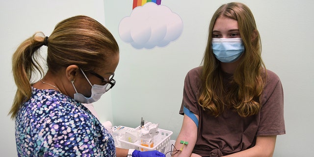 A coordenadora de pesquisa clínica Jeanette DeLeon coleta amostras de sangue de Brooke Stroud, de 16 anos, paciente em um ensaio clínico da vacina Moderna COVID-19 para adolescentes conduzido pelos Centros de Pesquisa Accel com o Nona Pediatric Center em Orlando, Flórida. 