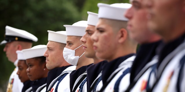 Members of the Navy Ceremonial Guard stand for the national anthem during a ceremony for National POW/MIA Recognition Day, at the U.S. Navy Memorial.