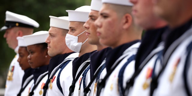 Members of the Navy Ceremonial Guard stand for the national anthem.