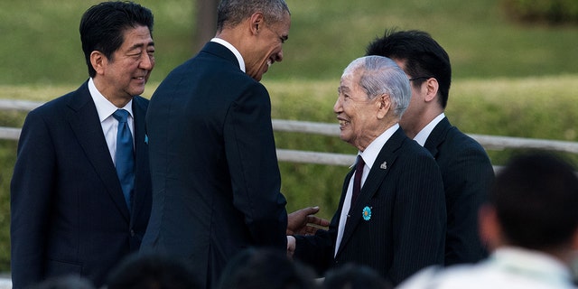U.S. President Obama (second from left) shakes hands with Sunao Tsuboi, a survivor of the atomic bombing of Hiroshima, as Japanese Prime Minister Shinzo Abe (left) looks on at the Hiroshima Peace Memorial park cenotaph in Hiroshima in May 2016.