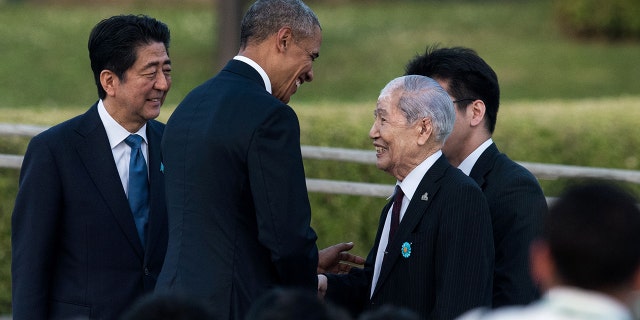 U.S. President Obama (second from left) shakes hands with Sunao Tsuboi, a survivor of the atomic bombing of Hiroshima, as Japanese Prime Minister Shinzo Abe (left) looks on at the Hiroshima Peace Memorial park cenotaph in Hiroshima in May 2016.