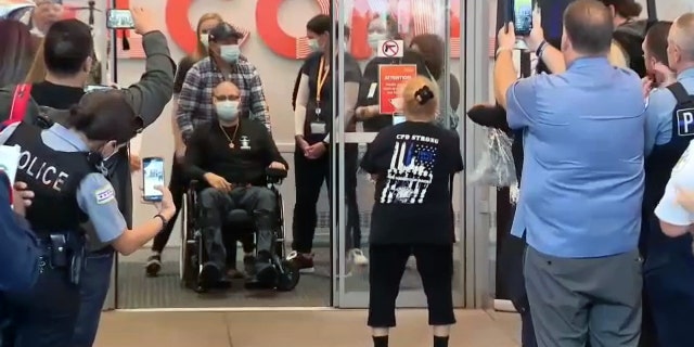 Carlos Yenez Jr is seen being greeted by a crowd and fellow officers outside Chicago's Shirley Ryan AbilityLab