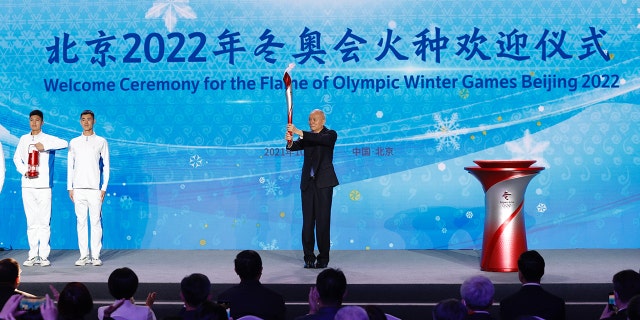 Cai Qi, chairman of the Beijing 2022 Olympic Winter Games Organizing Committee, holds the torch during the Beijing 2022 Olympic Winter Games torch welcoming ceremony at the Beijing Olympic Tower on Wednesday.