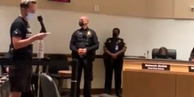 Man is removed from school board meeting after reading from a sexually-explicit book that was available in some district libraries.
