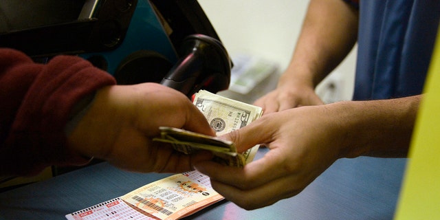 Pelanggan membeli tiket lotere untuk Powerball di toko CA Lotto di San Bernardino County, California, pada Januari 2016.  