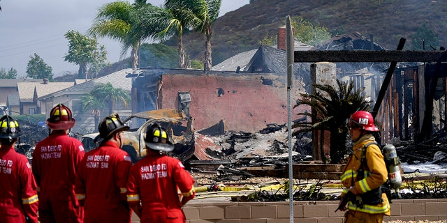 At least two people were killed and two others were injured when the plane crashed into a suburban Southern California neighborhood, setting two homes ablaze, authorities said. (AP Photo/Gregory Bull)