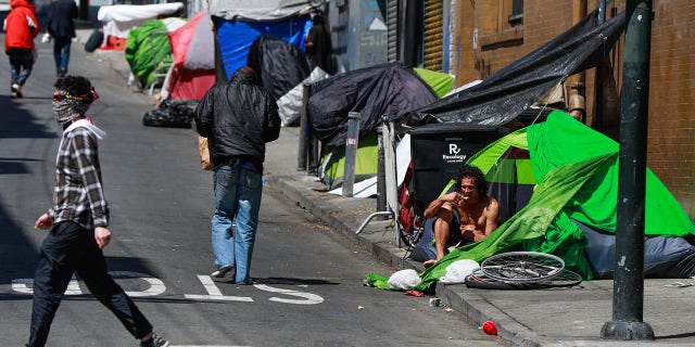 Homeless people gather on Willow Street in the Tenderloin on May 6, 2020, in San Francisco.