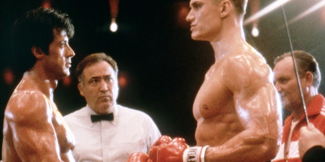 Sylvester Stallone and Dolph Lundgren hit boxing gloves in Rocky IV