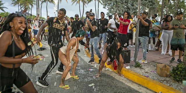 People party along Ocean Drive in the South Beach neighborhood of Miami, Florida, on Saturday, March 27, 2021. 