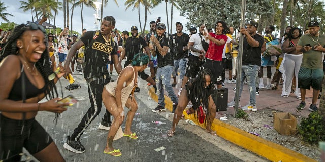 People party along Ocean Drive in the South Beach neighborhood of Miami, Florida, on Saturday, March 27, 2021.