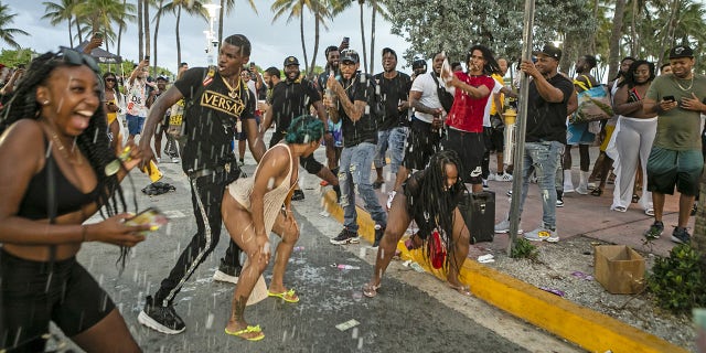 People party along Ocean Drive in the South Beach neighborhood of Miami, Florida, on Saturday, March 27, 2021. 