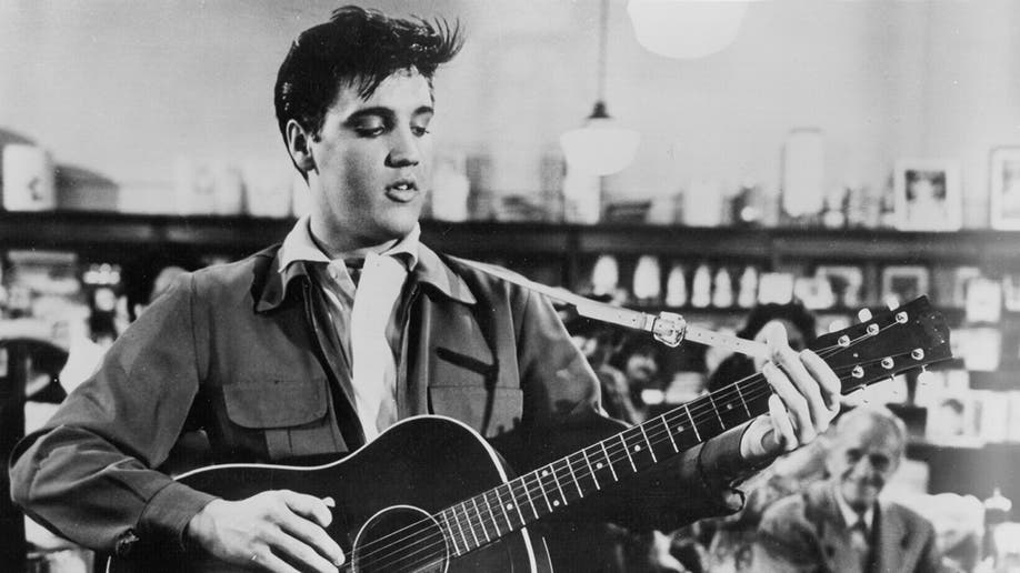 Elvis Presley strums guitar on set of movie