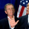 U.S. President-elect Bush (L) listens as retired General Colin Powell speaks to supporters and the press after Bush annouced Powell would serve as his Secretary of State in the his administration during a ceremony in Crawford, Texas, December 16, 2000. Powell served as Chairman of the Joints Chiefs of Staff under former President Bush's administration.
