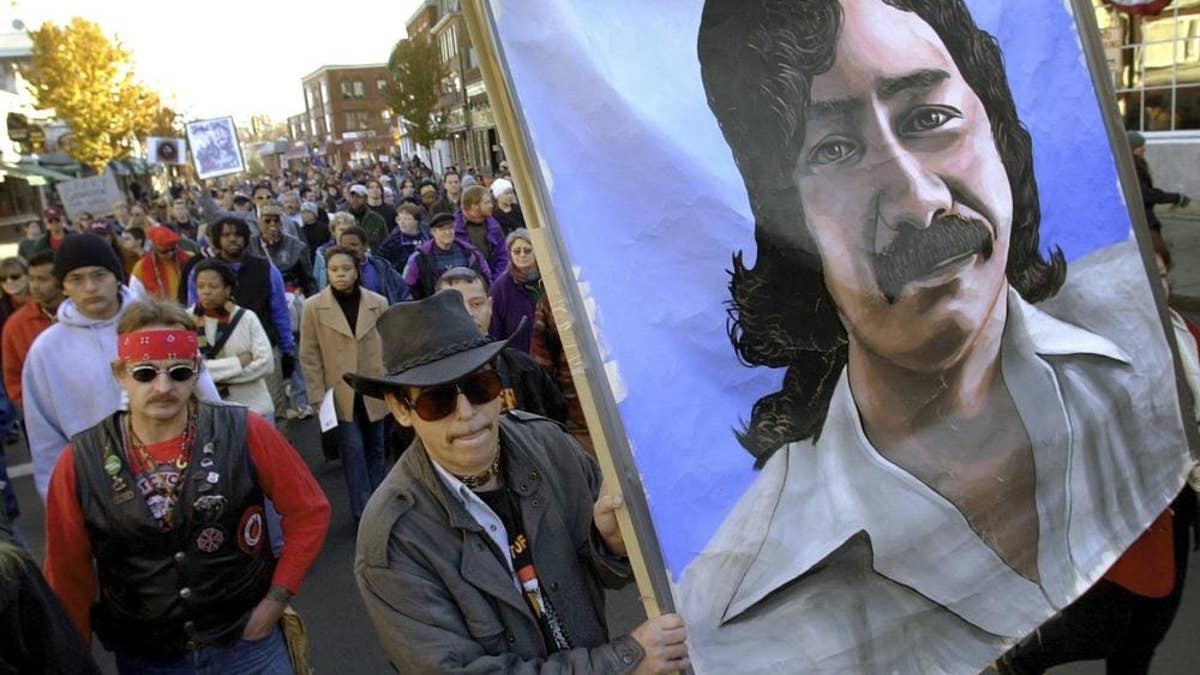 Marchers carry a large painting of jailed American Indian Leonard Peltier during a march for the National Day of Mourning in Plymouth, Massachusetts, on Nov. 22, 2001. Denouncing centuries of racism and mistreatment of Indigenous people, members of Native American tribes from around New England will gather on Thanksgiving 2021 for a solemn National Day of Mourning observance.