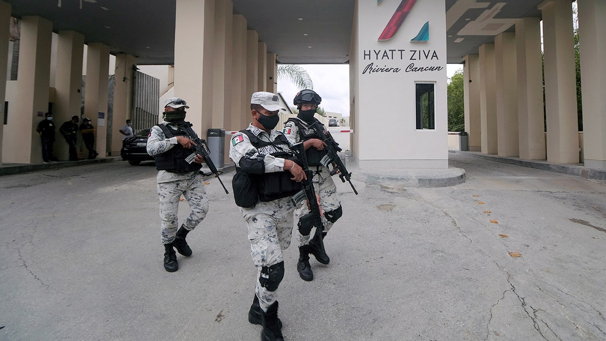 Members of the National Guard walk by the entrance of a hotel after two suspected drug gang members were shot dead in a beachfront clash between rival groups near the Mexican resort of Cancun, in Puerto Morelos, Mexico Nov. 4, 2021. Mexico will deploy a battalion of National Guard troops to its Mayan Riviera in the wake of a spate of shootings that have put the crown jewel of the country’s tourism industry on edge, officials said Wednesdsay.