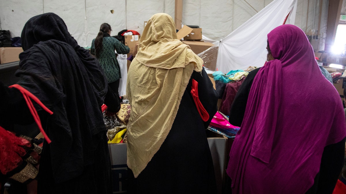Afghan refugees look for donated clothing and shoes at the donation center at Fort McCoy U.S. Army base, in Wisconsin Sept. 30, 2021. 