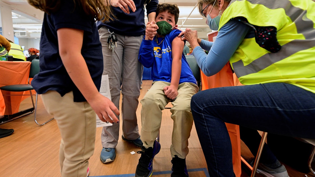 A child reacts while receiving a dose of the Pfizer-BioNTech coronavirus disease (COVID-19) vaccine 