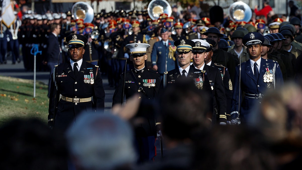 U.S. troops march during a joint full honors procession evoking the original 1921 funeral procession of a World War I unknown soldier, in commemoration of the 100th anniversary of the Tomb of the Unknown Soldier on Veterans Day in Arlington National Cemetery in Arlington, Virginia, U.S., November 11, 2021. REUTERS/Jonathan Ernst/Pool