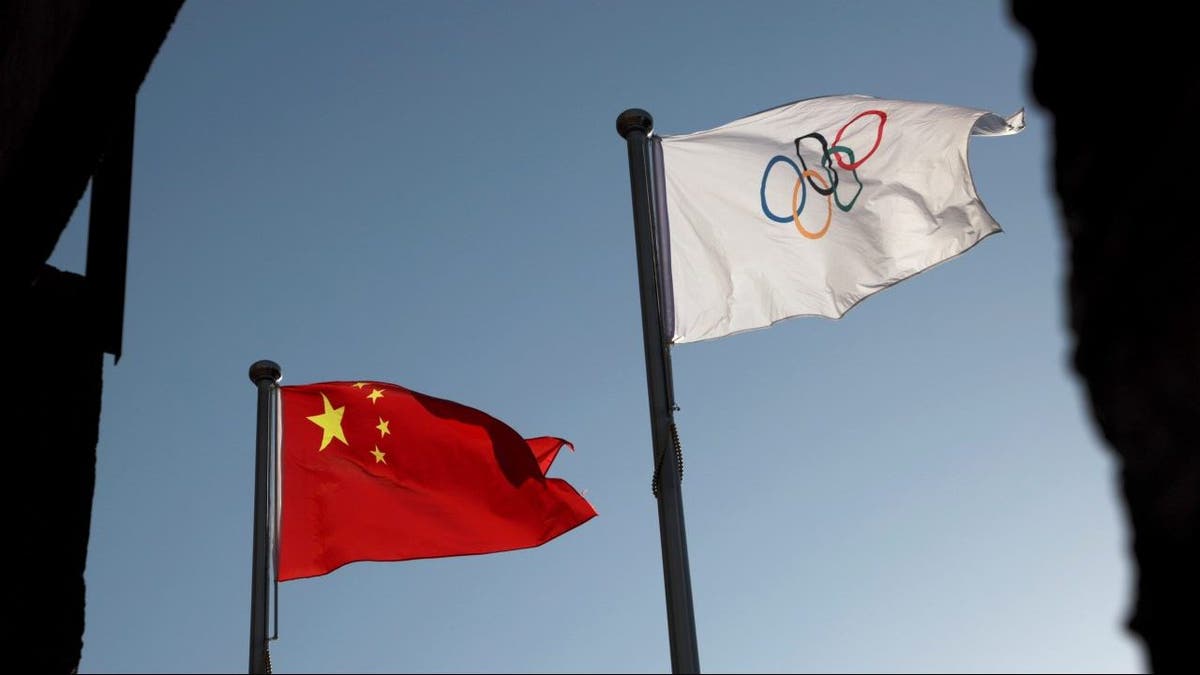 FILE PHOTO: The Chinese and Olympic flags flutter at the headquarters of the Beijing Organising Committee for the 2022 Olympic and Paralympic Winter Games in Beijing, China November 12, 2021. 