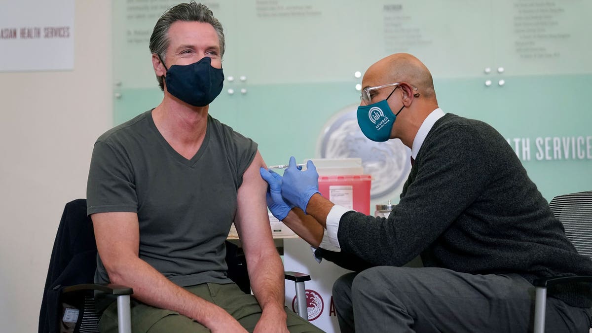 California Gov. Gavin Newsom receives a Moderna COVID-19 vaccine booster shot from California Health and Human Services Secretary Dr. Mark Ghaly in Oakland, California, on Oct. 27, 2021.