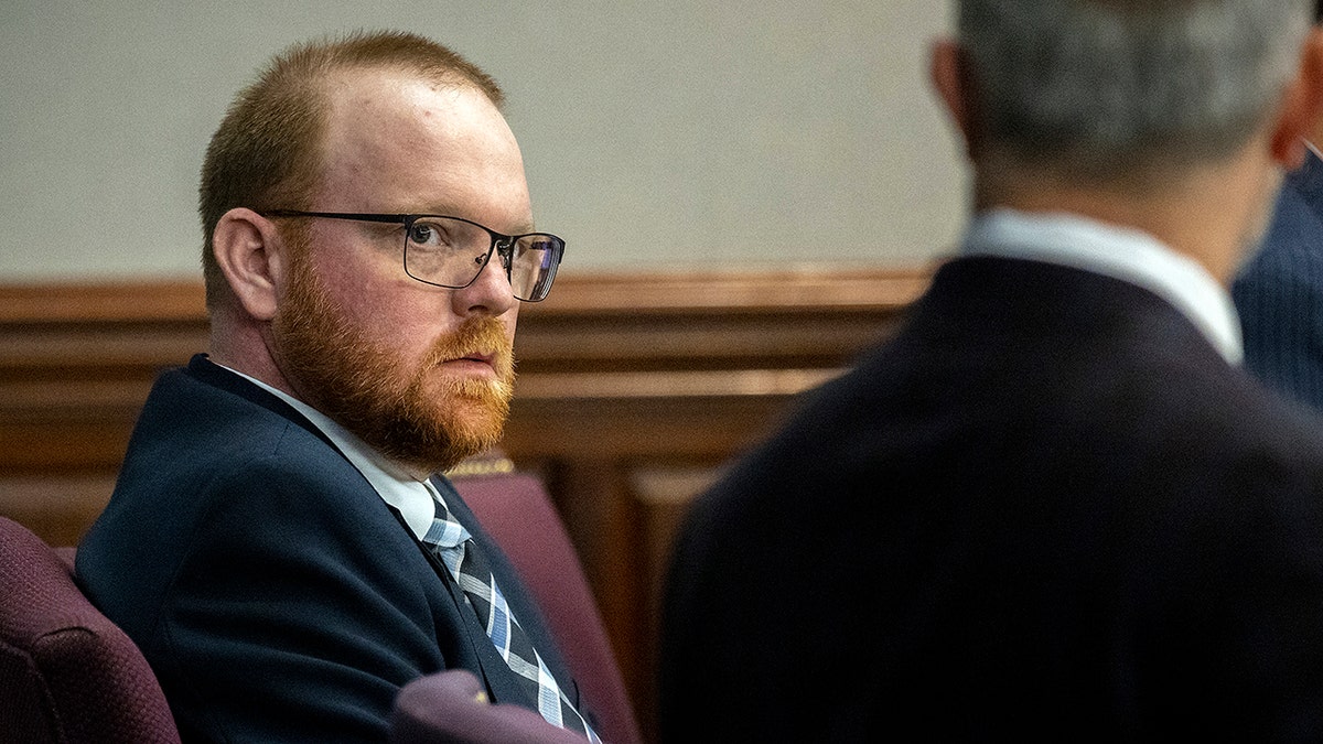 Travis McMichael listens to one of his attorneys during a motion hearing in the Glynn County Courthouse, Thursday, Nov. 4, 2021, in Brunswick, Ga. McMichael and his his father, Greg McMichael, and a neighbor, William "Roddie" Bryan, are charged with the February 2020 slaying of 25-year-old Ahmaud Arbery. (AP Photo/Stephen B. Morton, Pool)
