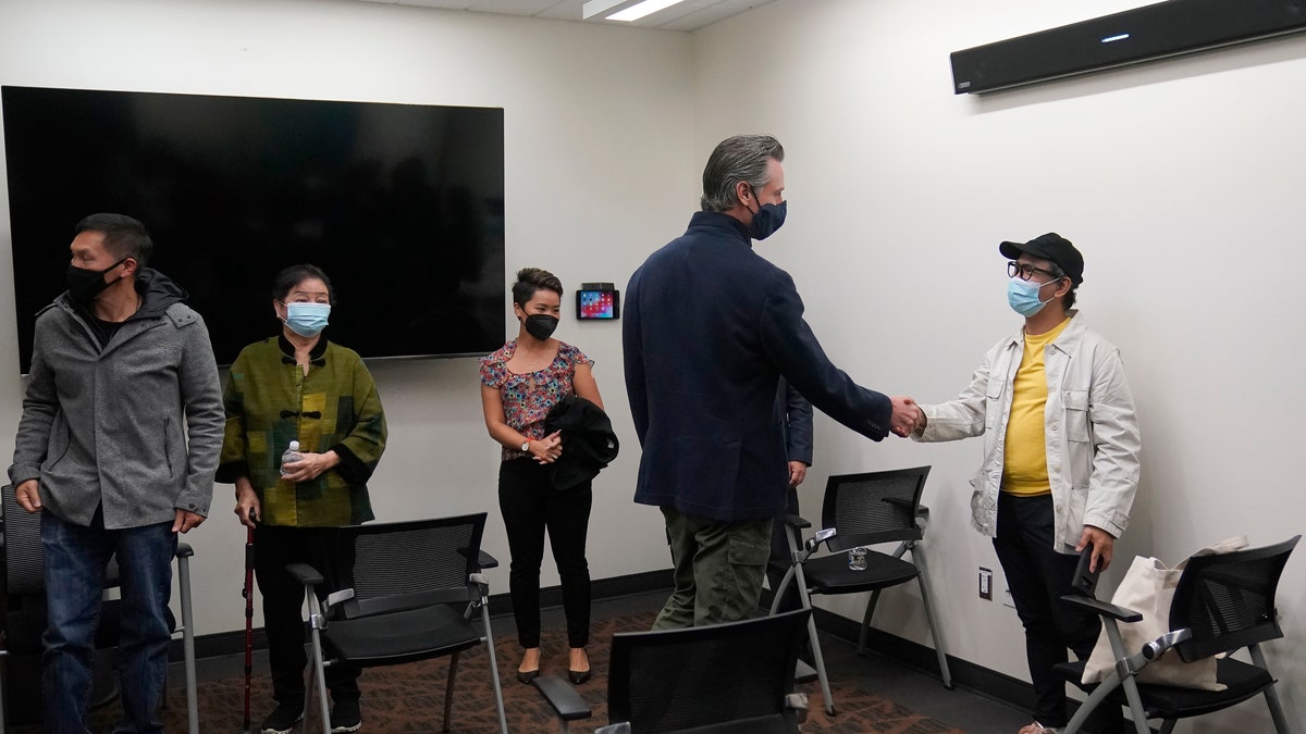 Gov. Gavin Newsom, middle right, greets patients before he received a Moderna COVID-19 vaccine booster shot at Asian Health Services in Oakland, Calif., Wednesday, Oct. 27, 2021. (AP Photo/Jeff Chiu)