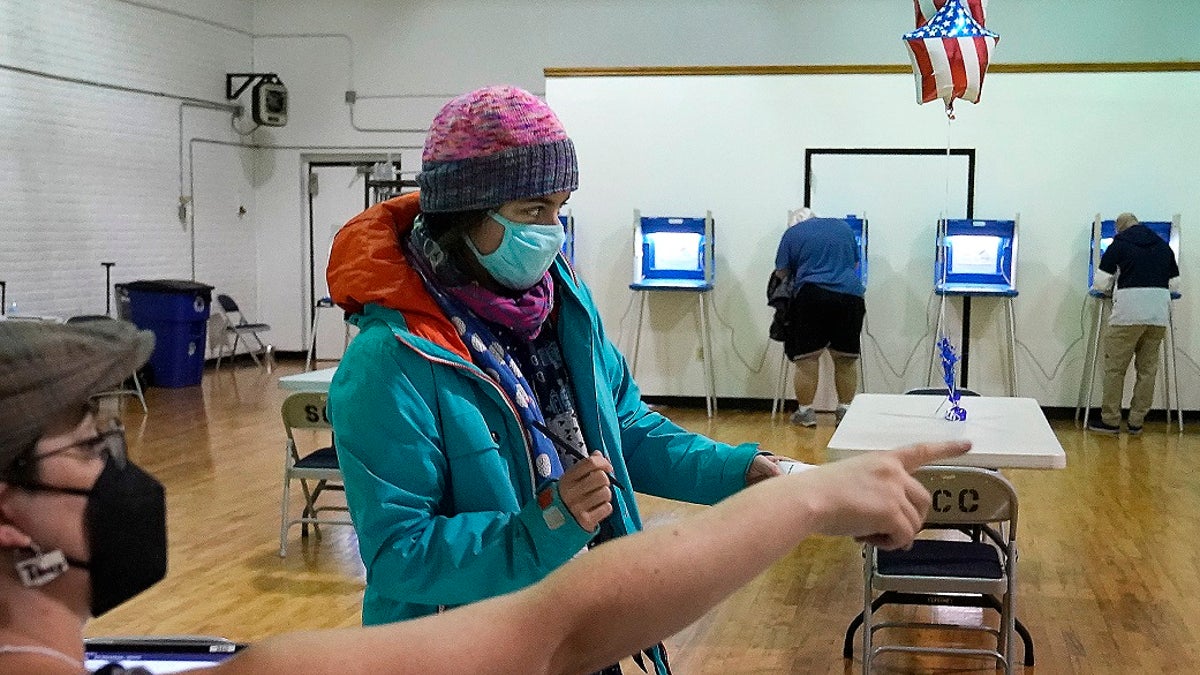 Monica Rojas gets directions from a poll worker on her way to casting her ballot at Sabathani Community Center during municipal elections on Tuesday in Minneapolis. Voters in Minneapolis are deciding whether to replace the city’s police department with a new Department of Public Safety. The election comes more than a year after George Floyd’s death launched a movement to defund or abolish police across the country.(David Joles /Star Tribune via AP)