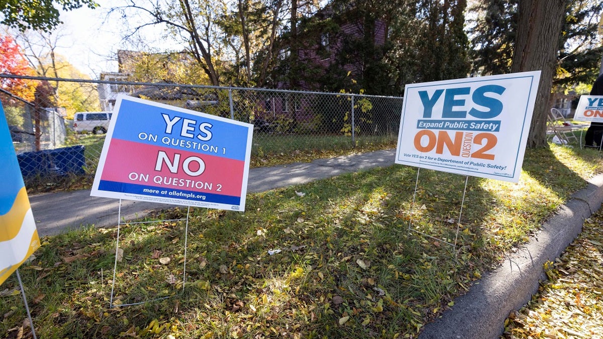 Lawn signs conflict with each other outside of a polling place on Tuesday in Minneapolis. (AP Photo/Christian Monterrosa)