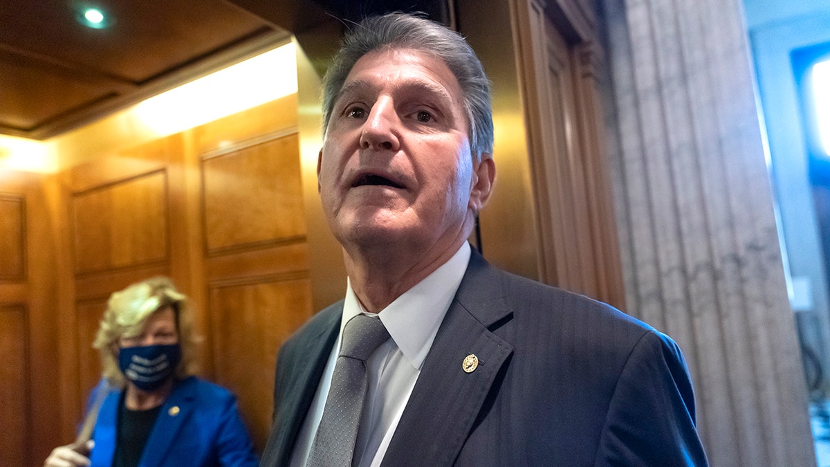 Sen. Joe Manchin, D-WVa., who has been a key holdout on President Joe Biden's ambitious domestic package, peers out from an elevator after a vote, at the Capitol in Washington, Wednesday, Nov. 3, 2021. Progressive and centrist lawmakers, particularly Manchin and Sen. Kyrsten Sinema, D-Ariz., have fought over details of the sprawling 1,600-page package. (AP Photo/J. Scott Applewhite)