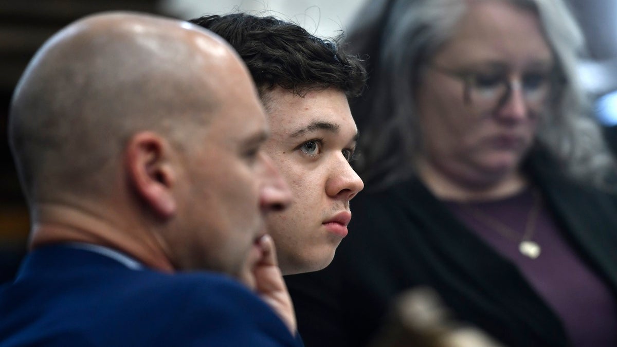 Kyle Rittenhouse, center, looks up and away from a video monitor as footage of him shooting on the night of Aug. 25, 2020, is shown during the trial on Wednesday, Nov. 3 2021.