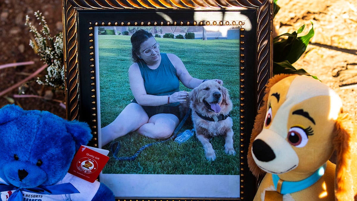 A photography of Tina Tintor, 23, and her dog is placed at a makeshift memorial site to honor them at South Rainbow Boulevard and Spring Valley Parkway, on Thursday, Nov. 4, 2021, in Las Vegas. Tintor and her dog were killed when Raiders wide receiver Henry Ruggs, accused of DUI, slammed into the rear of Tintor's vehicle.