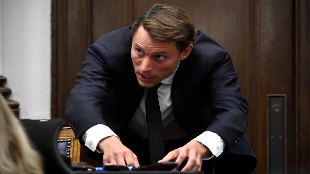 Richard "Richie" McGinniss, chief video director of The Daily Caller, demonstrates how Joseph Rosenbaum dove to the ground while testifying during Kyle Rittenhouse's trial at the Kenosha County Courthouse in Kenosha, Wis., on Thursday, Nov. 4, 2021. (Sean Krajacic/The Kenosha News via AP, Pool)