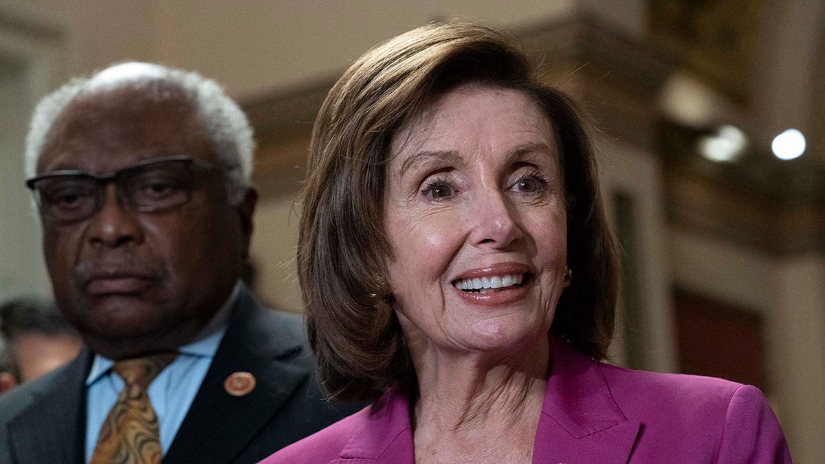 House Speaker Nancy Pelosi, D-Calif., accompanied by House Majority Whip James Clyburn, D-S.C., speaks to reporters at the Capitol in Washington, Friday, Nov. 5, 2021. 