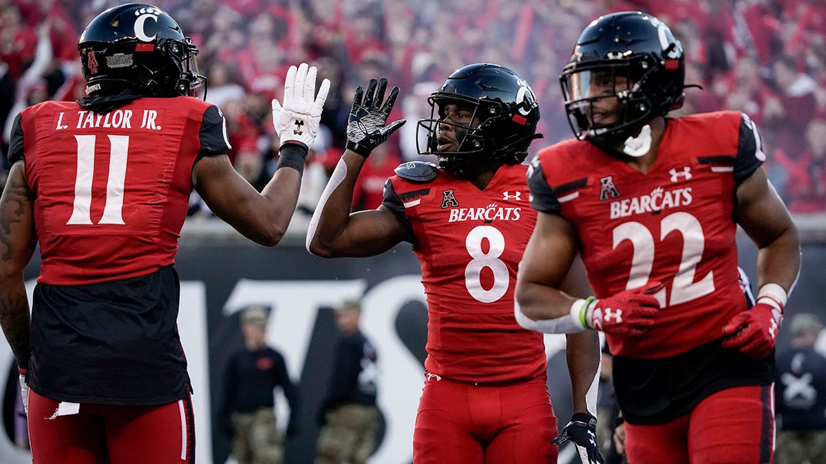 Cincinnati wide receiver Michael Young Jr. (8) celebrates with tight end Leonard Taylor (11) after scoring a touchdown during the second half of an NCAA college football game against Tulsa Saturday, Nov. 6, 2021, in Cincinnati. (AP Photo/Jeff Dean)
