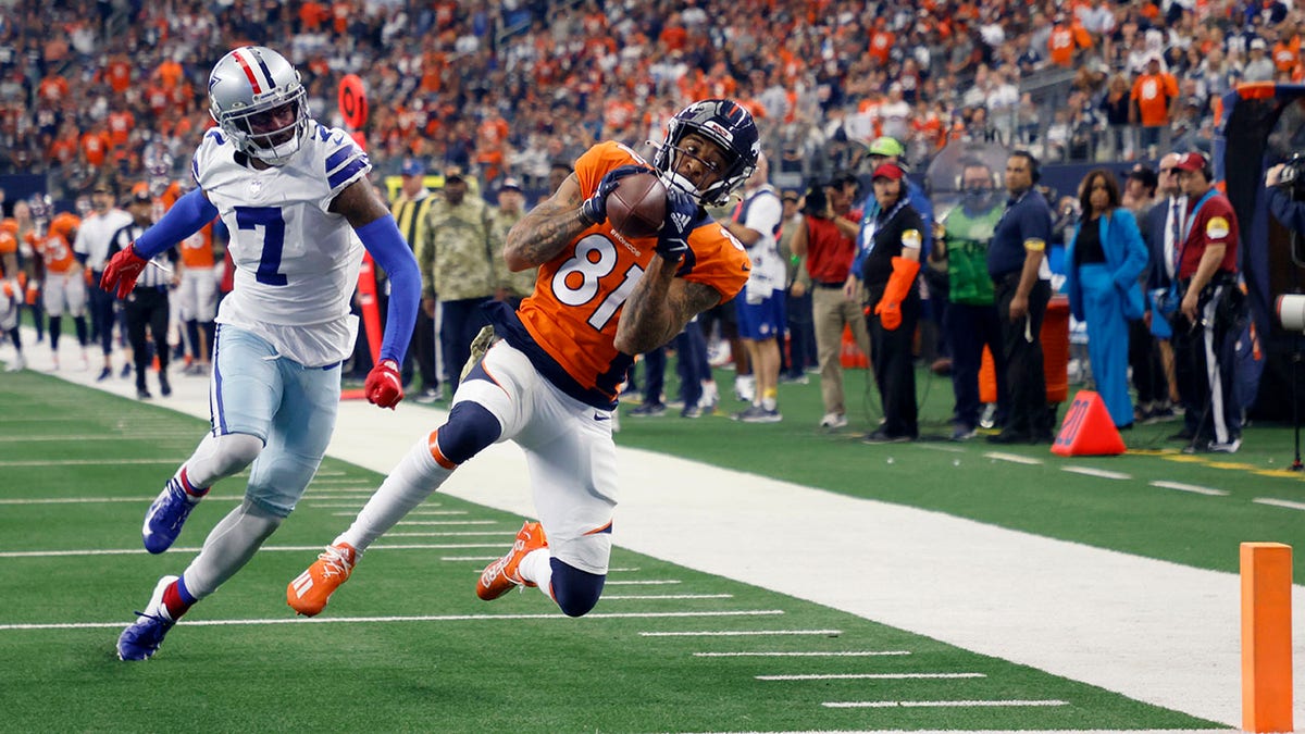 Dallas Cowboys cornerback Trevon Diggs (7) defends as Denver Broncos wide receiver Tim Patrick (81) catches a touchdown pass in the first half in Arlington, Texas, Sunday, Nov. 7, 2021.