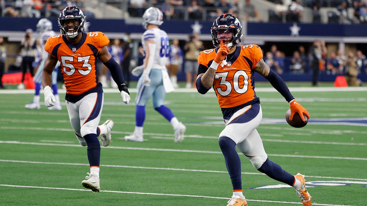 Denver Broncos Jonathon Cooper (53) and safety Caden Sterns (30) celebrate after Sterns intercepted a pass thrown by Dallas quarterback Dak Prescott in the second half in Arlington, Texas, Sunday, Nov. 7, 2021. 